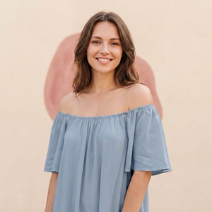 Frau im staubblauen Off-Shoulder-Sommerkleid